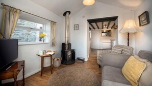 A cozy living room with a fireplace, a television, and a sofa. - Eisteddfa Country House and Cottages (Criccieth)