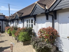 A row of white buildings with dark roofs and numbered doors.
