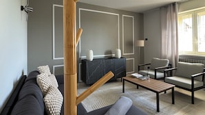 Una sala de estar moderna con sofá, sillones, una mesa de centro y chimenea.