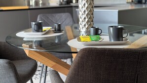 Una cocina moderna con una mesa de vidrio, una cafetera y un hervidor.