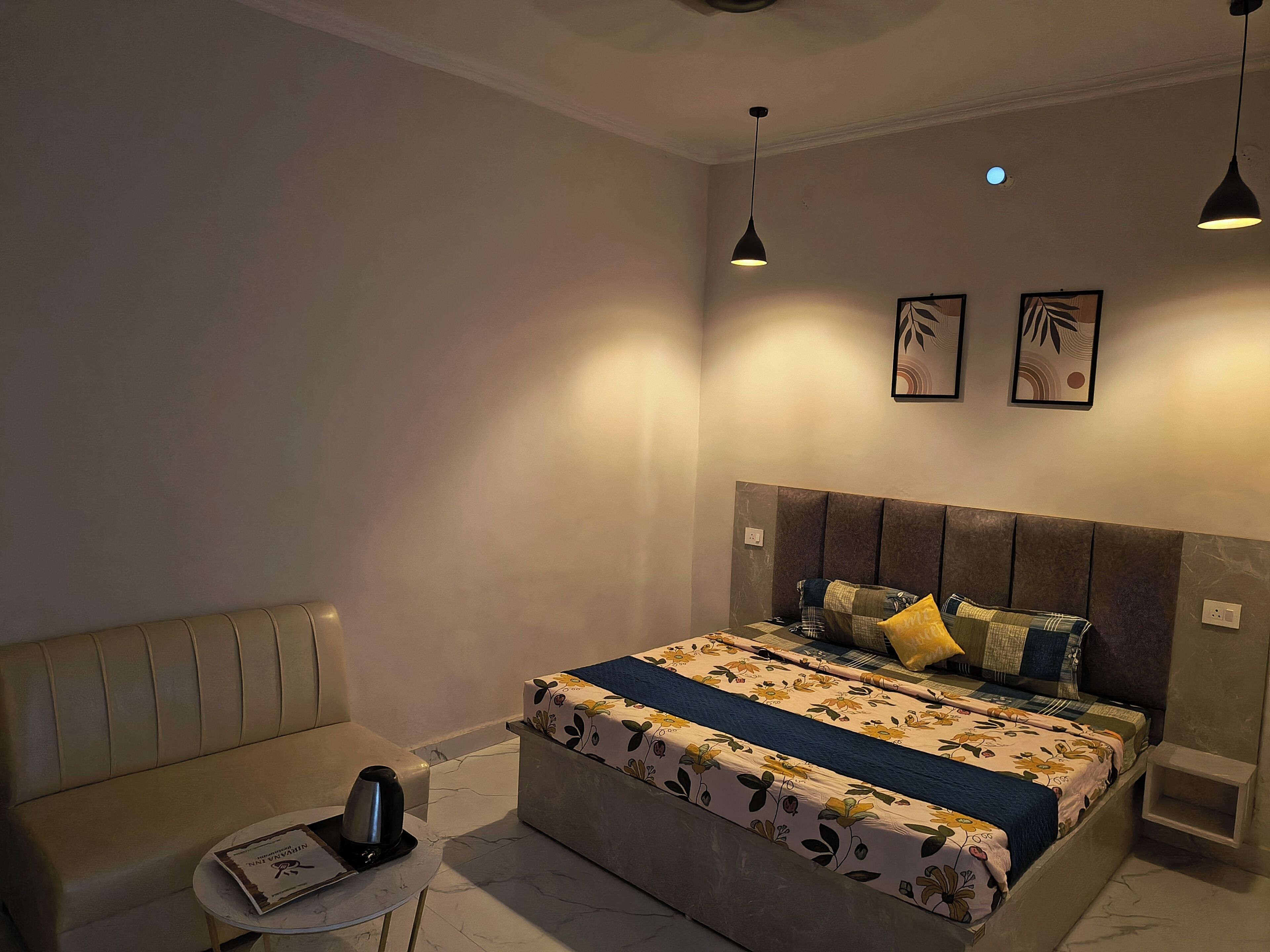 A bedroom with a bed, bedside tables, a sofa, and a coffee table.