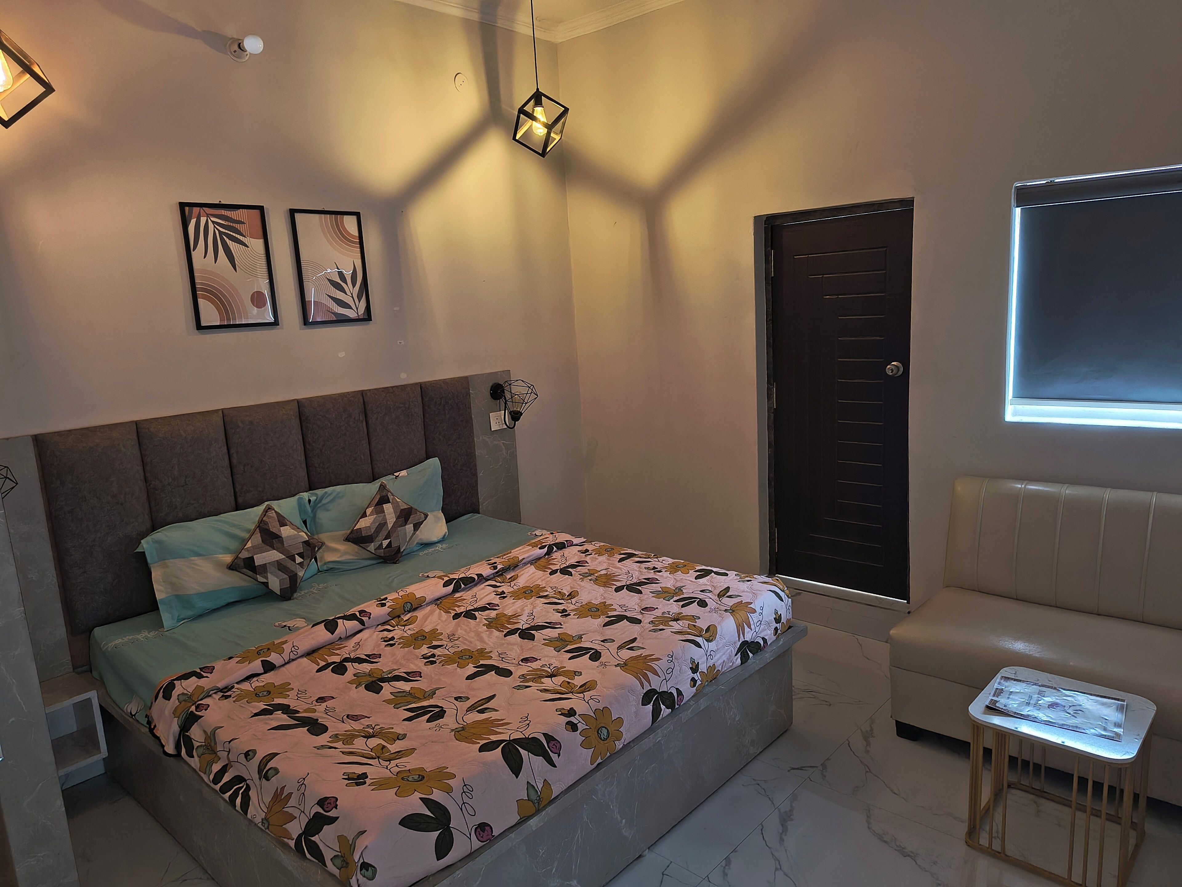 Une chambre à coucher avec un lit, une table de chevet, une fenêtre et une porte.