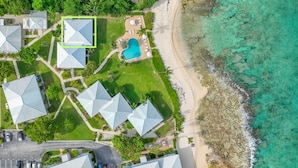 Vista aerea di un resort con diversi edifici, una piscina e una spiaggia.
