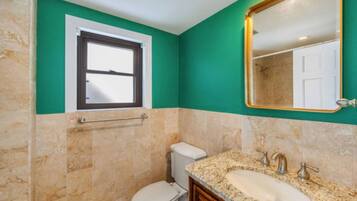 Ein Badezimmer mit Toilette, Waschbecken und Fenster.