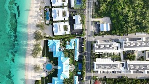 Vue aérienne d’un complexe hôtelier comprenant plusieurs bâtiments, une piscine et une plage.