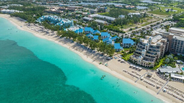A coastal resort with beachfront villas, a sandy beach, and a view of the ocean.