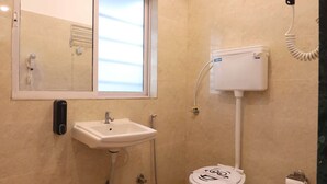 A bathroom with a sink, toilet, and a window.