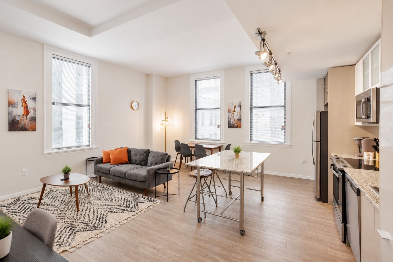 A modern apartment with a dining area, kitchen, and living space.
