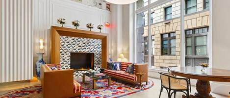 Una sala de estar moderna con chimenea, sofás, una mesa de centro y una mesa de comedor.
