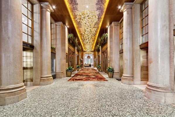 A grand hallway with marble floors, columns, and a decorative ceiling. - CozySuites - Sky Central (Cincinnati)