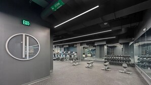Ein modernes Fitnessstudio mit Laufbändern, Hanteln und Bänken.