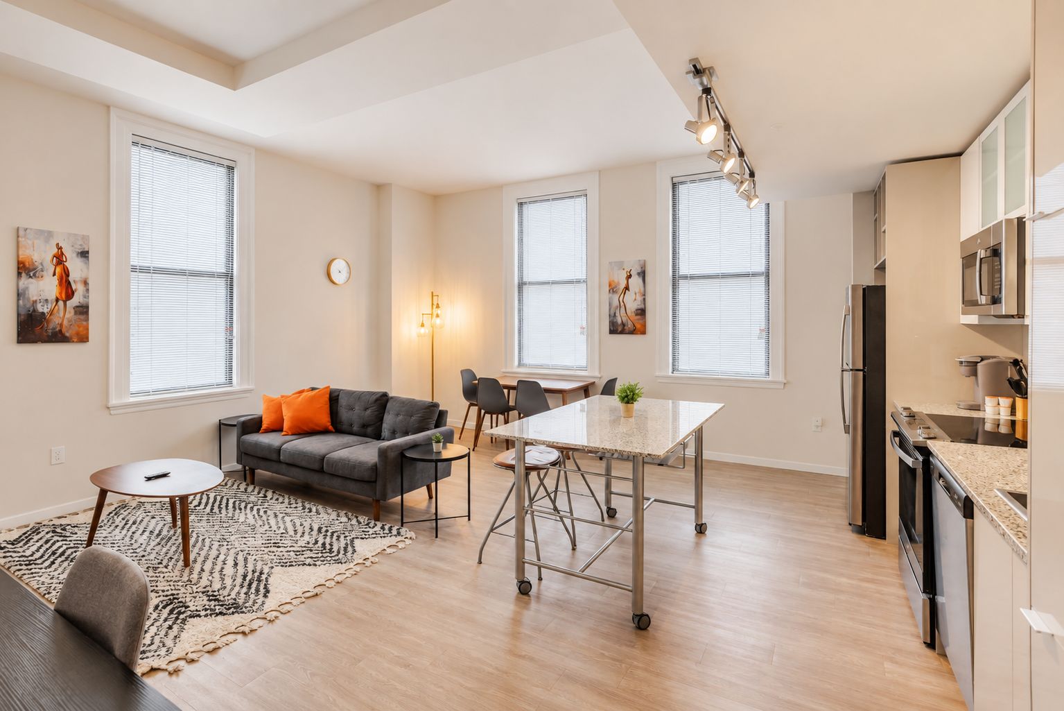 A modern apartment with a dining area, kitchen, and living space.