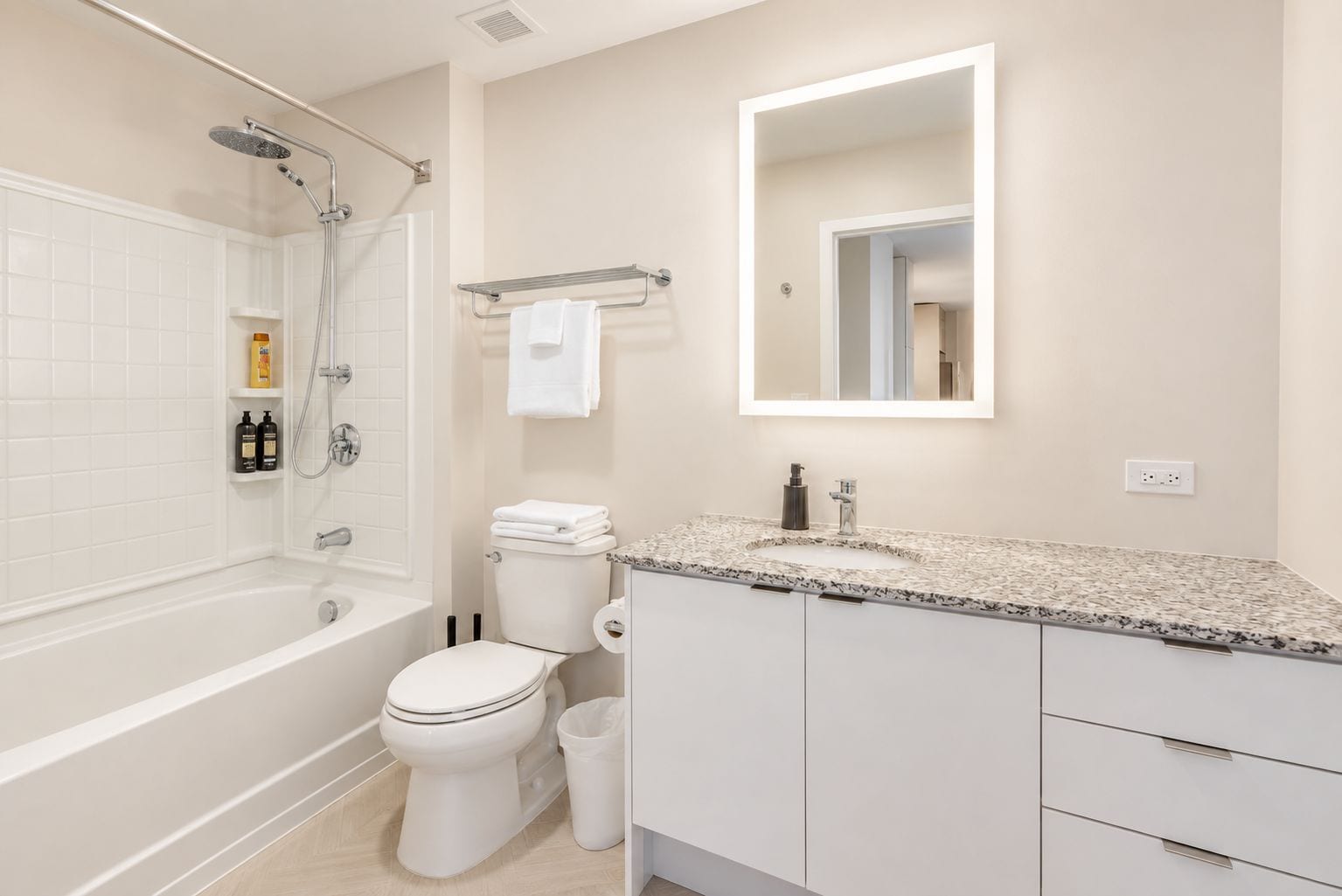 Une salle de bain moderne équipée d’une baignoire, de toilettes et d’un meuble-lavabo.