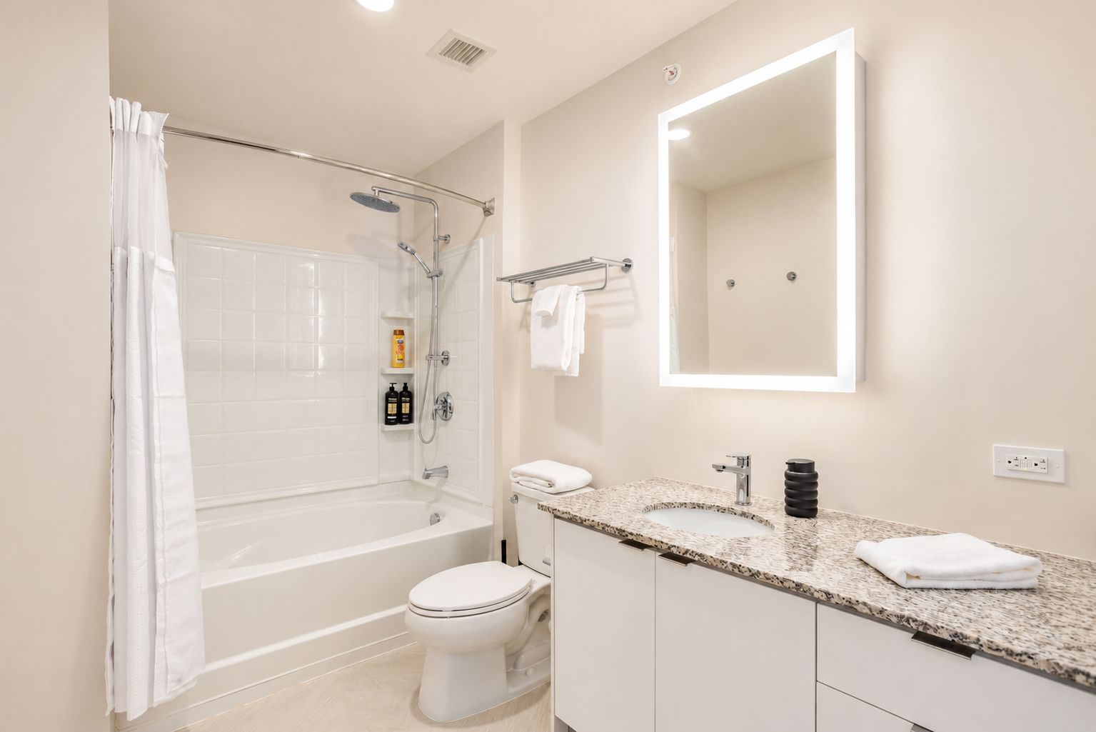 Un baño moderno con ducha, inodoro y lavamanos.