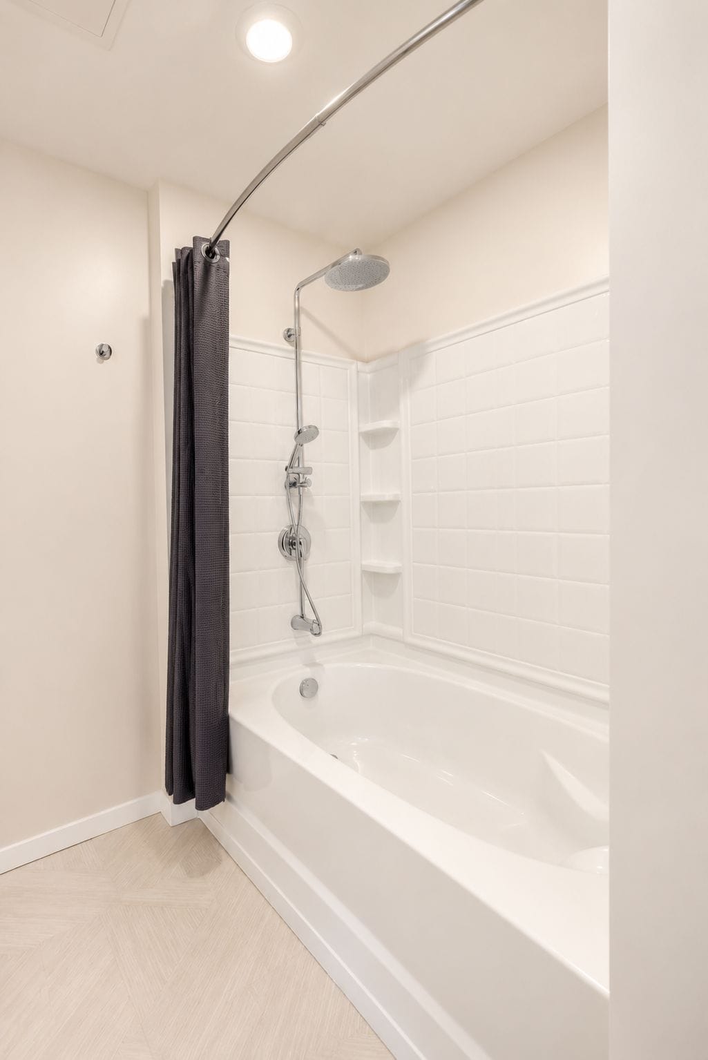 A modern bathroom with a freestanding bathtub, a showerhead, and a towel rack.