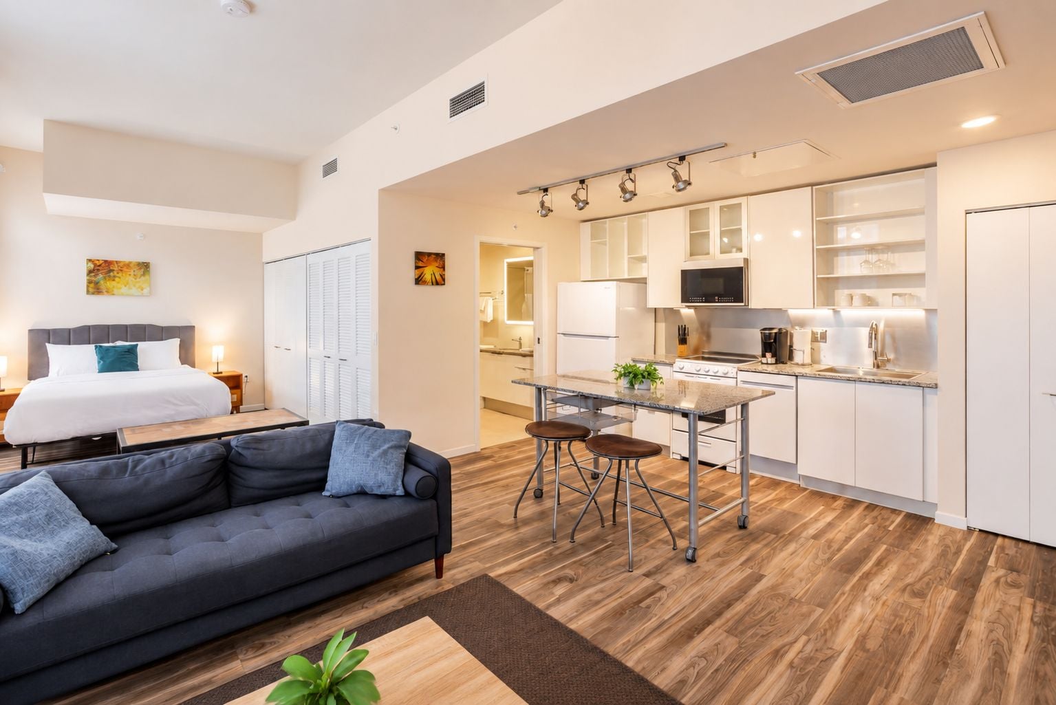 Un apartamento moderno con sala de estar, kitchenette y una cama.