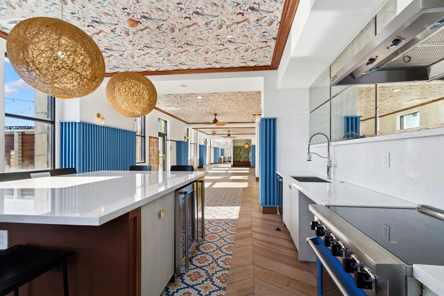 Una cocina moderna con una isla central, un ventanal grande y un techo con diseño.