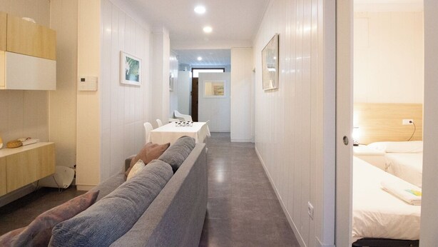 Hotellihuone, jossa on sohva, pieni pöytä ja sänky.