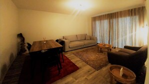 A living room with a sofa, a dining table, and a coffee table. - Tahiti - Urban Maohi Cottage (Papeete)