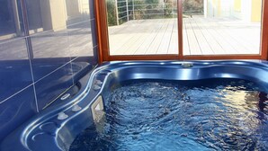 Un bain à remous avec une terrasse en bois à l’extérieur.