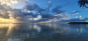 Een rustige zee met heldere lucht en een klein eiland in de verte.
