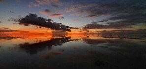 A calm body of water reflecting a sunset sky with clouds. - Moorea - Tropical Moana Cottage (Moorea-Maiao)