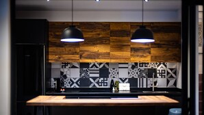 Une cuisine moderne avec un îlot central en bois, des luminaires suspendus et un pare-feu décoratif.