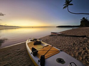 A kayak on a sandy beach with calm water and a sunset in the background. - Moorea - Tropical Bungalow (Moorea-Maiao)