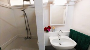 A bathroom with a shower, a sink, and a mirror. - Tahiti - Matavai Bay Cottage (Arue)