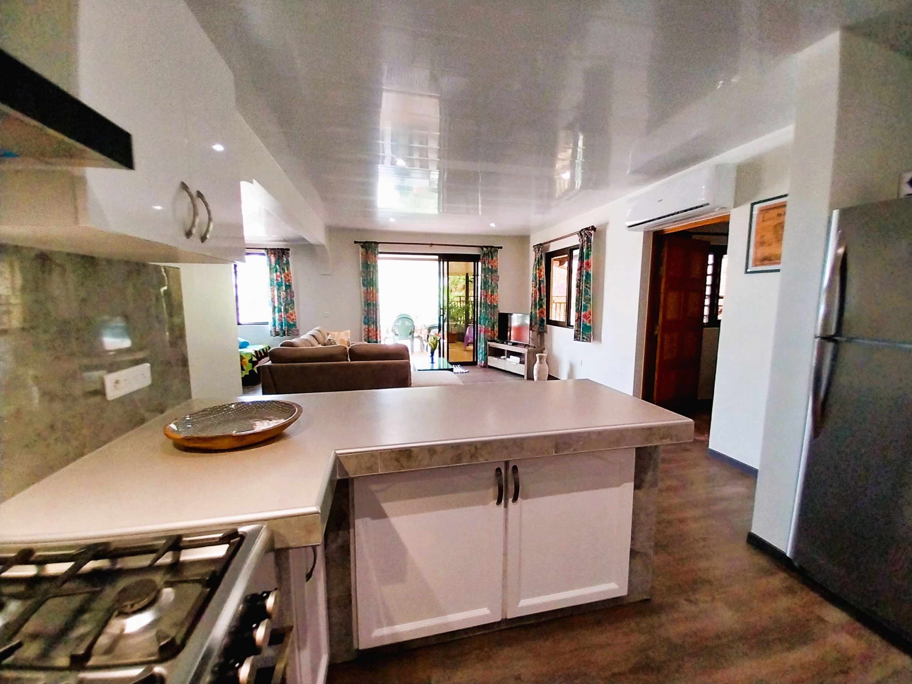 A modern kitchen with a central island, a stove, and a refrigerator.
