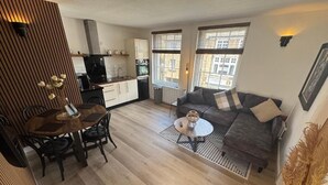 A modern living room with a sofa, coffee table, and dining area.