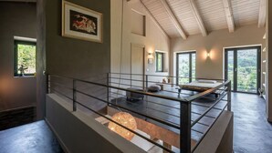 A modern interior with a staircase leading to a balcony, a bed with a view, and a framed picture on the wall. - Wonderful private villa for 6 people with private pool, WIFI, TV, patio and pets allowed (Bossolasco)