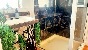 Een douche, handdoeken, zeep, toiletpapier