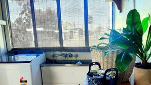 A compact kitchen with a sink, a small refrigerator, and a window with blinds. - Oakwood House at Wild Wood Park Retreat | 5-Bedroom home for Families & Groups (Tambo)