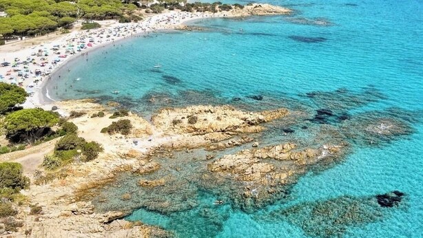 An aerial view of a coastal area with a beach, clear turquoise waters, rocky outcrops, and distant mountains. - Villa le palme, 500 mt from the beaches of Sas Linnas Siccas Bay. (Orosei)