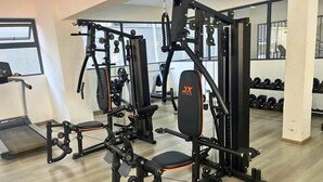 Ein Fitnessstudio mit Trainingsgeräten, Laufbändern und Hanteln.