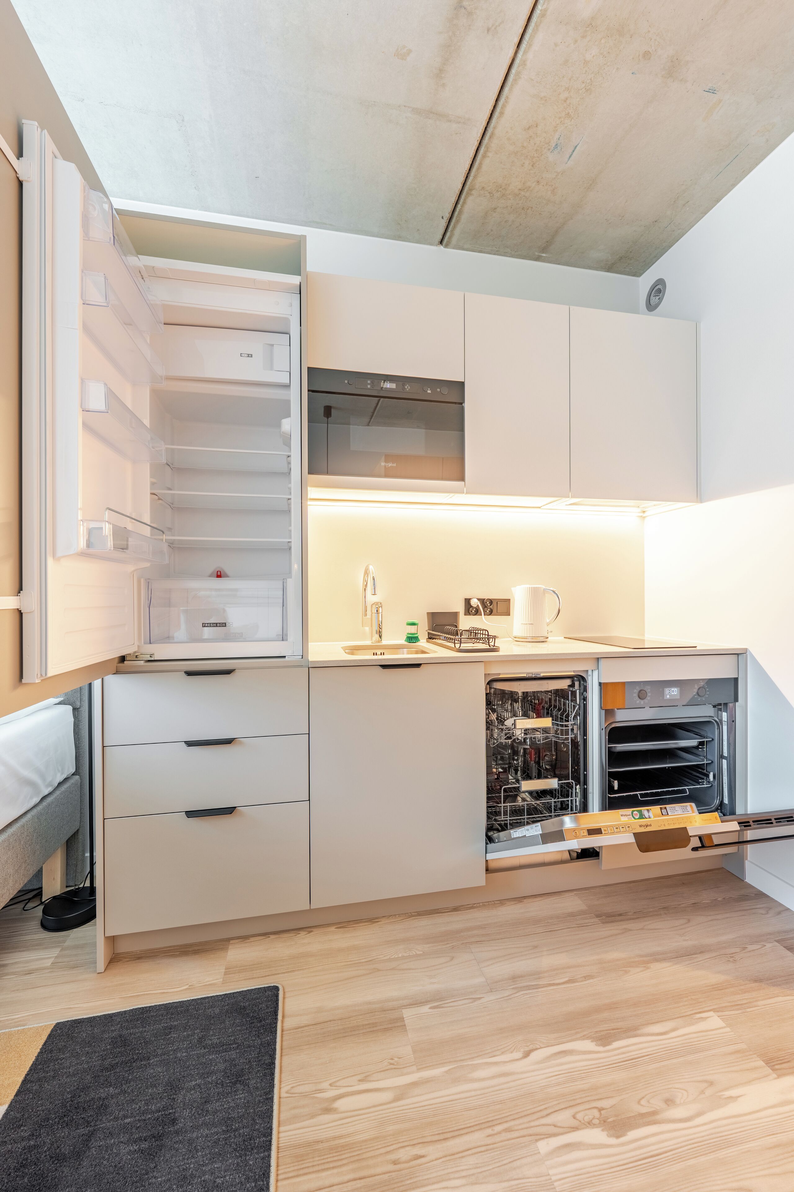 A compact kitchen with a built-in dishwasher, a microwave, and a small countertop area.