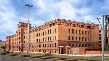 Un edificio grande y de estilo histórico de ladrillo, con muchas ventanas y una entrada destacada.