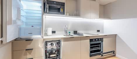 Cocina compacta con horno integrado, lavavajillas y microondas.