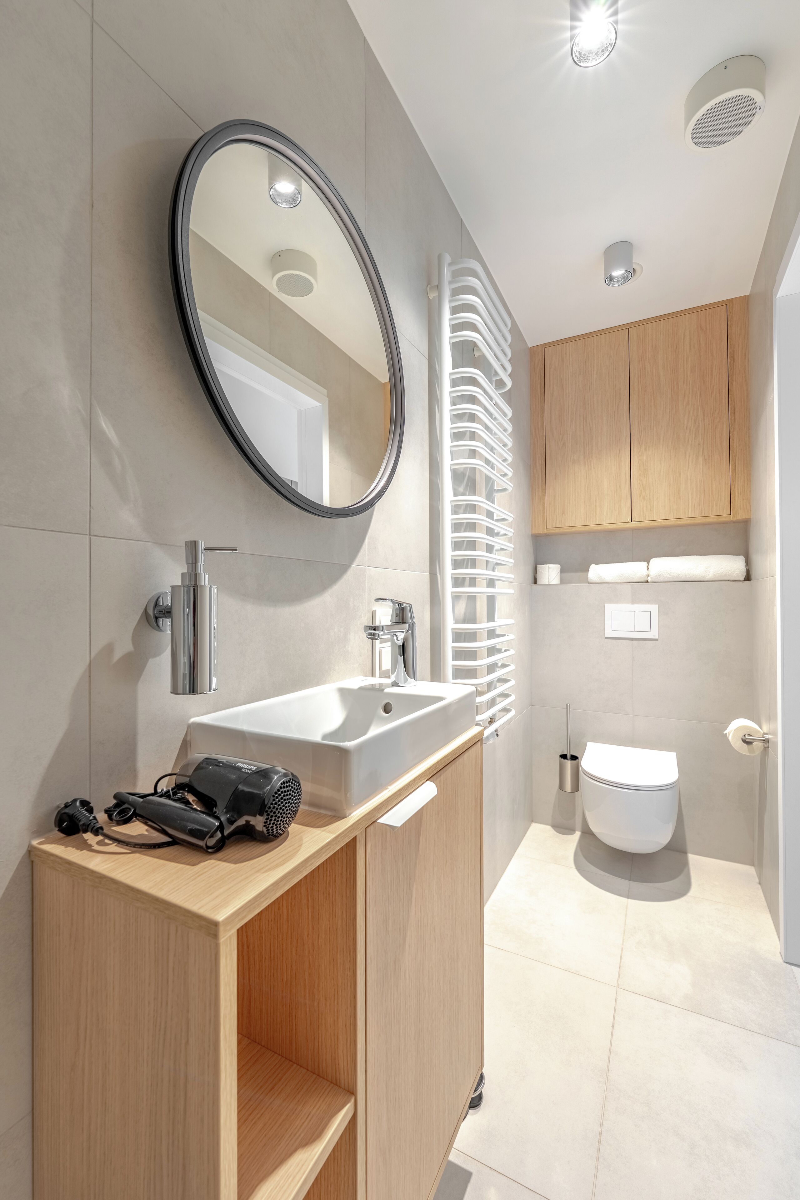 Une salle de bain moderne avec un grand miroir, un lavabo et des toilettes.