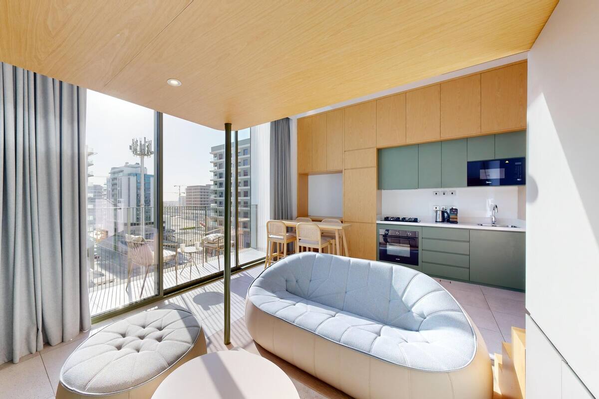 A modern apartment with a balcony, a dining area, and a kitchen.