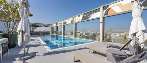 Una piscina al aire libre de temporada, sillones reclinables de piscina