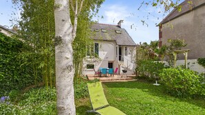 A house with a garden, a green lawn, and a white wall. - House 30m from the beach - Large garden - for 6 (Ile Tudy)