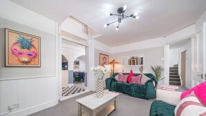 Una sala de estar moderna con un sofá verde, una mesa de centro blanca y un cuadro en la pared.