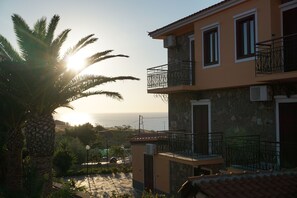 Un immeuble de deux étages doté de balcons, d’une façade en pierre et offrant une vue sur la mer.