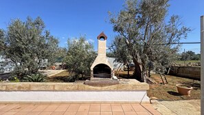 An outdoor brick oven structure surrounded by olive trees and a paved area. - Villa Ulivo Sleeps 7 Garden Close to the sea (Alliste)