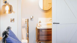 Un dormitorio con cama, cómoda, espejo, lavabo y puerta.