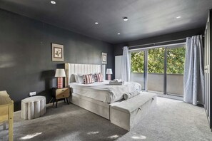 A bedroom with a large bed, bedside tables, a nightstand, a bench, and a window with curtains. - Relaxing & Spacious Family Home - By Tempstay (Berkshire)