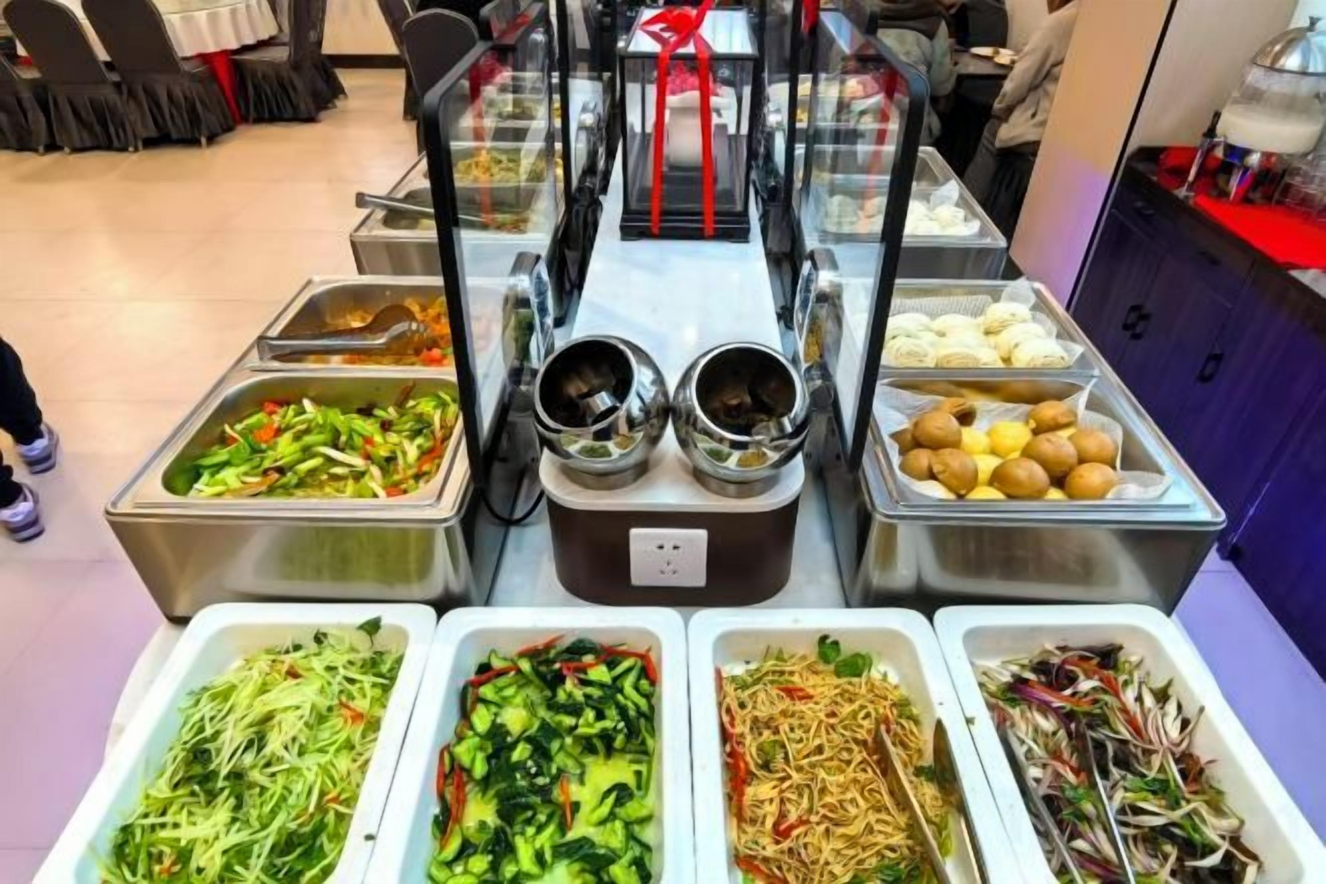 A buffet with various food options including salads, noodles, and other dishes.