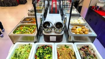 A buffet with various food options including salads, noodles, and other dishes.